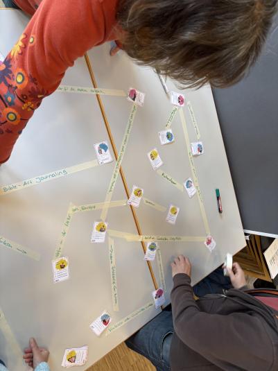 Menschen schauen auf einen tisch mit Bildern von Personen mit Verbindungen