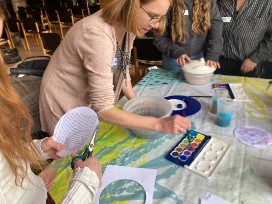 Von einem Wassermalkasten wir Wasser in eine Salatschleuder gegeben
