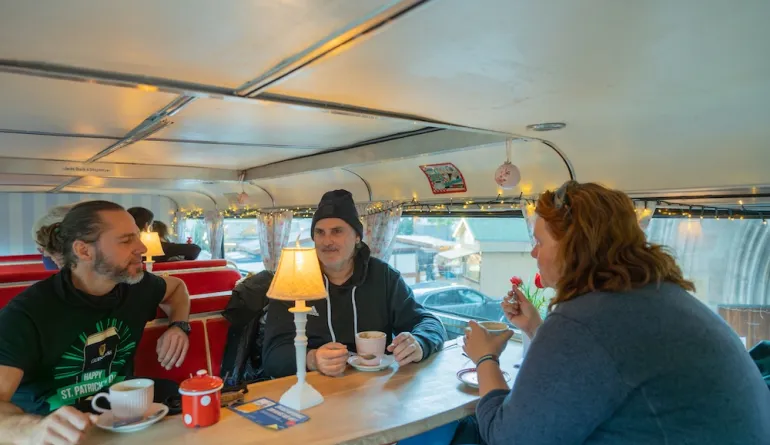 Gäste genießen heiße Getränke im Cafe-Bus
