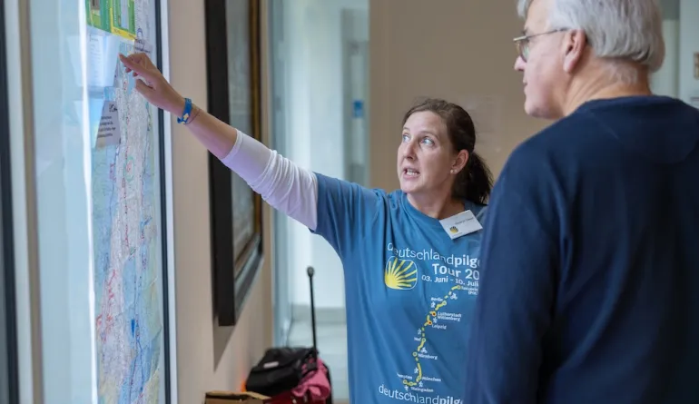 Frau informiert Besucher über das Projekt "Deutschland pilgert"