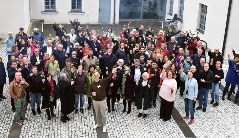 Menschen in einer Gruppe, die Wunderkerzen in der Hand halten und vor dem Gebäude stehen