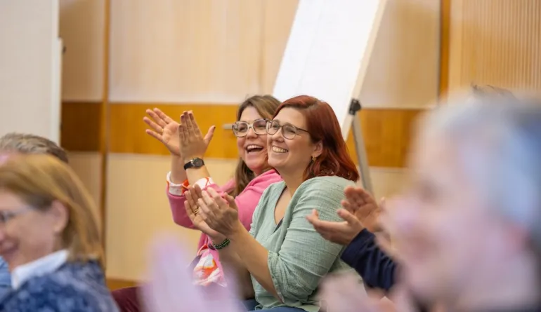zwei Teilnehmende applaudieren begeistert