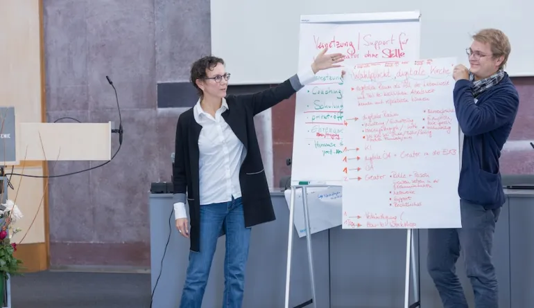 Präsentation der Ergebnisse, zwei Personen stellen eine Flipchart vor