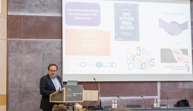 Kirchenrat Michael Wolf steigt ins Thema der Zukunftswerkstatt ein, im Hintergrund ein Beamer