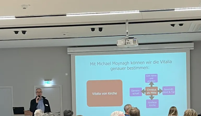 Menschen die gespannt nach vorne schauen und zuhören