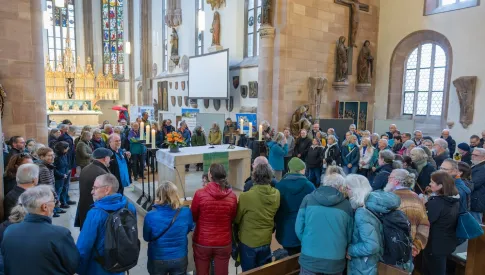Besucher:innen stehen um den Altar zum Reisesegen versammelt