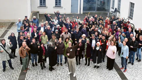 Menschen in einer Gruppe, die Wunderkerzen in der Hand halten und vor dem Gebäude stehen