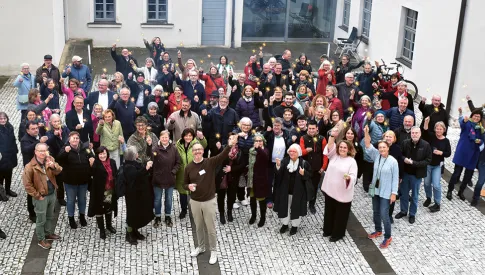 Menschen in einer Gruppe, die Wunderkerzen in der Hand halten und vor dem Gebäude stehen